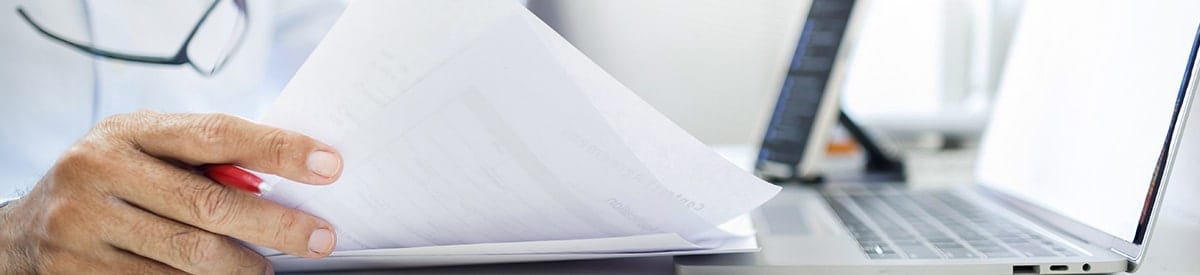 書類の束を持つ手のクローズアップ